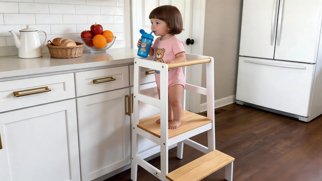 Toddler standing safely on a sturdy wooden Montessori tower with anti-slip steps and secure guardrails in a kitchen.