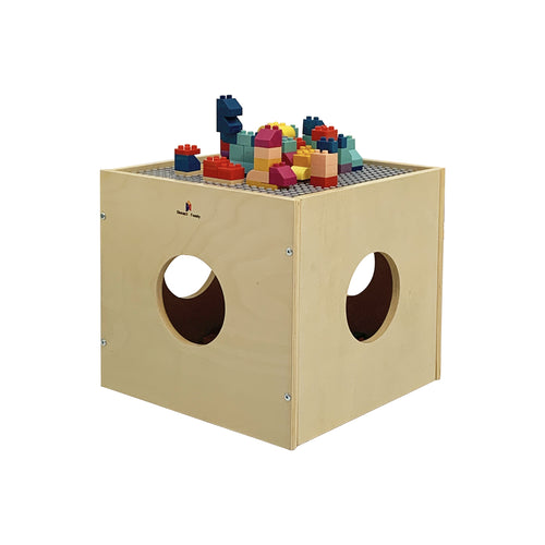 Child building Lego on wooden cube with storage holes