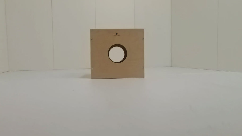 Toddler building on Montessori activity cube's Lego top, while parents store toys in side storage holes. Natural wood finish blends with home decor.