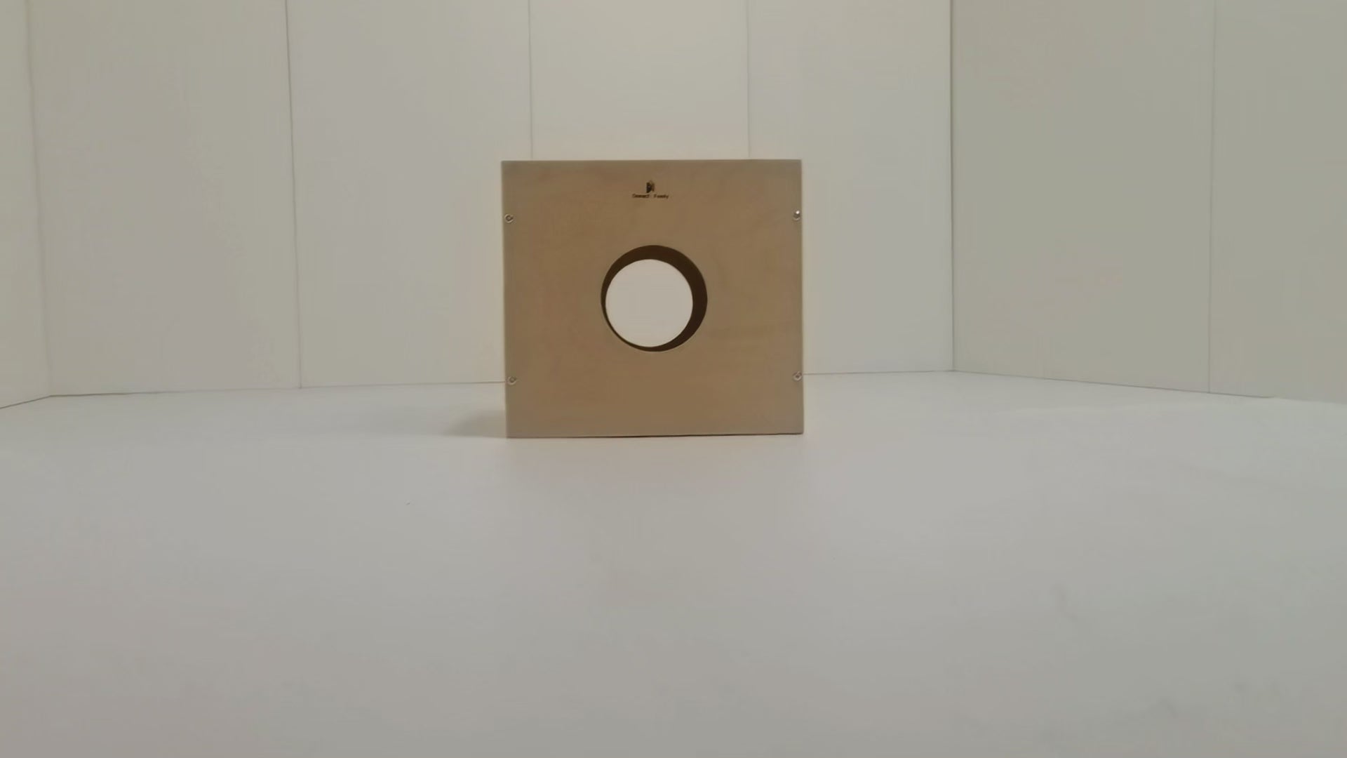 Toddler building on Montessori activity cube's Lego top, while parents store toys in side storage holes. Natural wood finish blends with home decor.